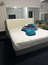 Bed lacking a flat sheet between blanket and mattress.