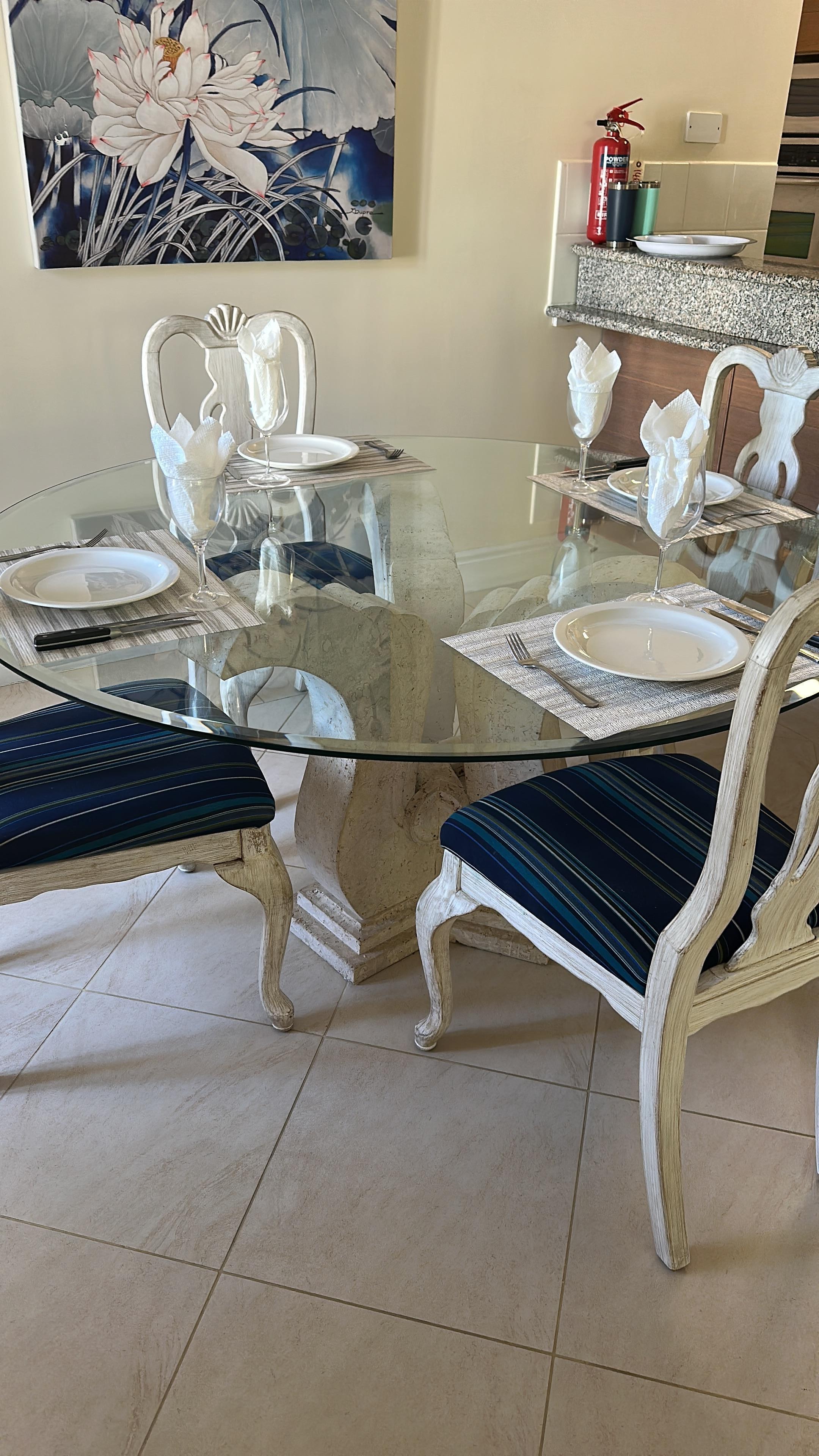 Lovely seating area  that can seat up to six people.  The round glass table keeps the airy feeling.  Great area to play a board game which we are here. Fun!