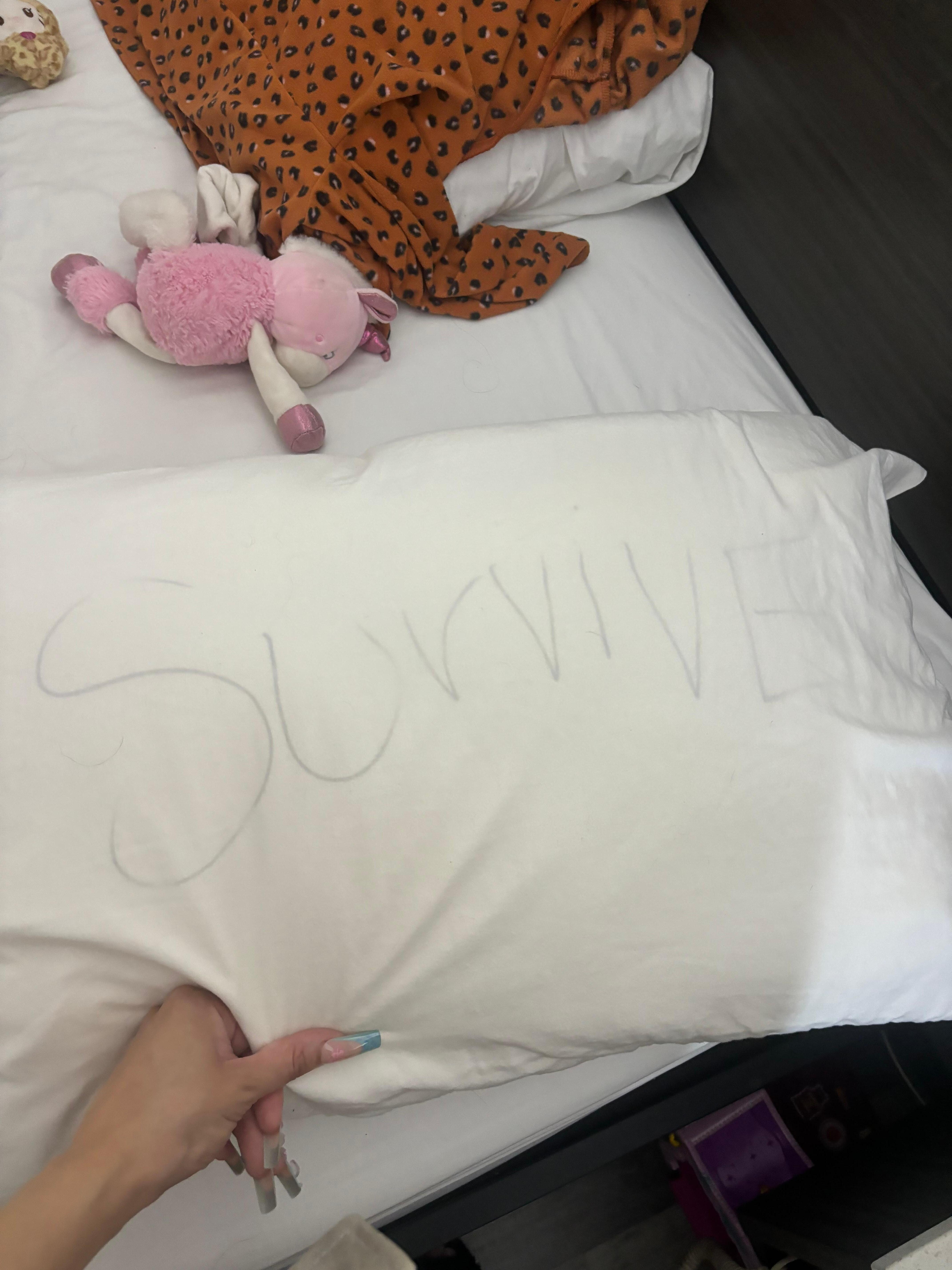 The word survive written on bed pillow
