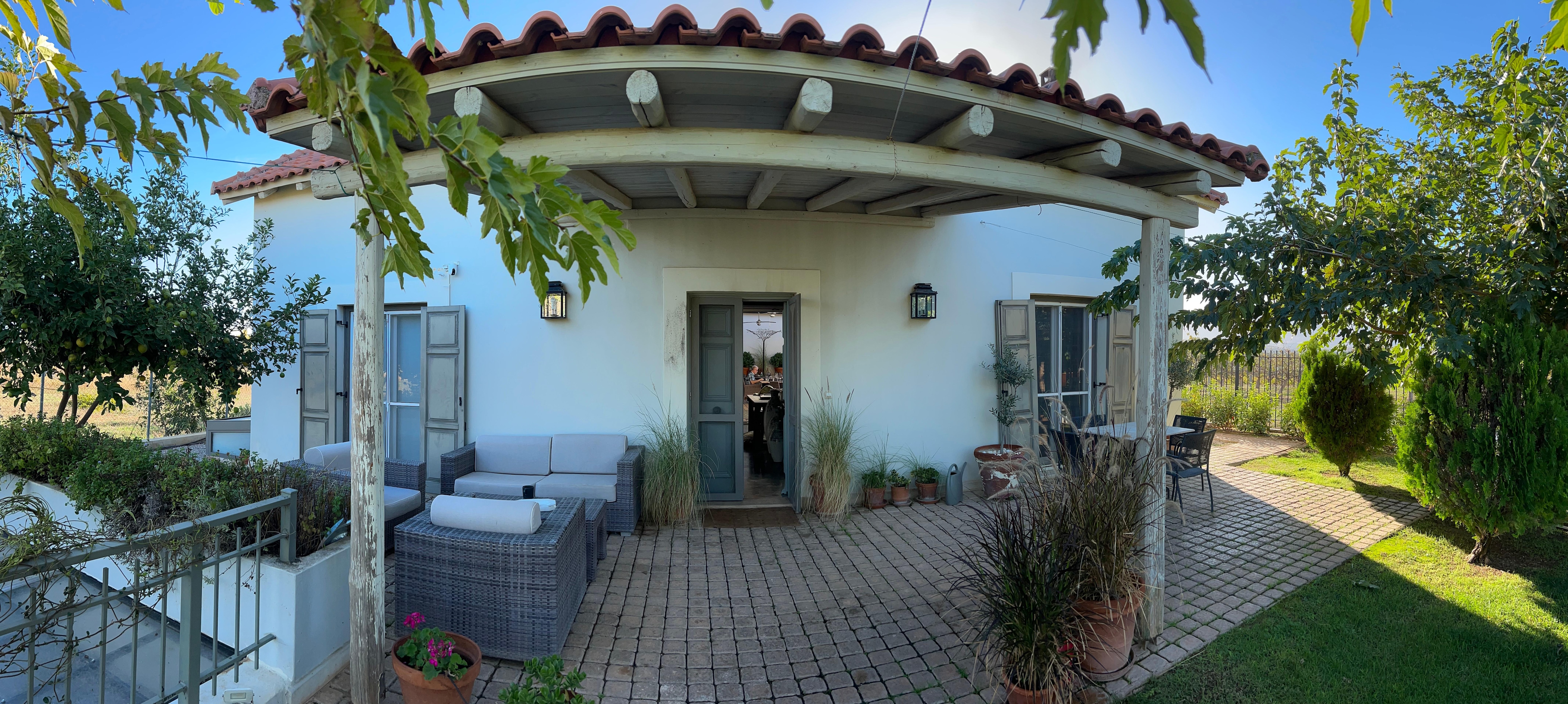 Front with lemon and mulberry trees and outdoor seating.