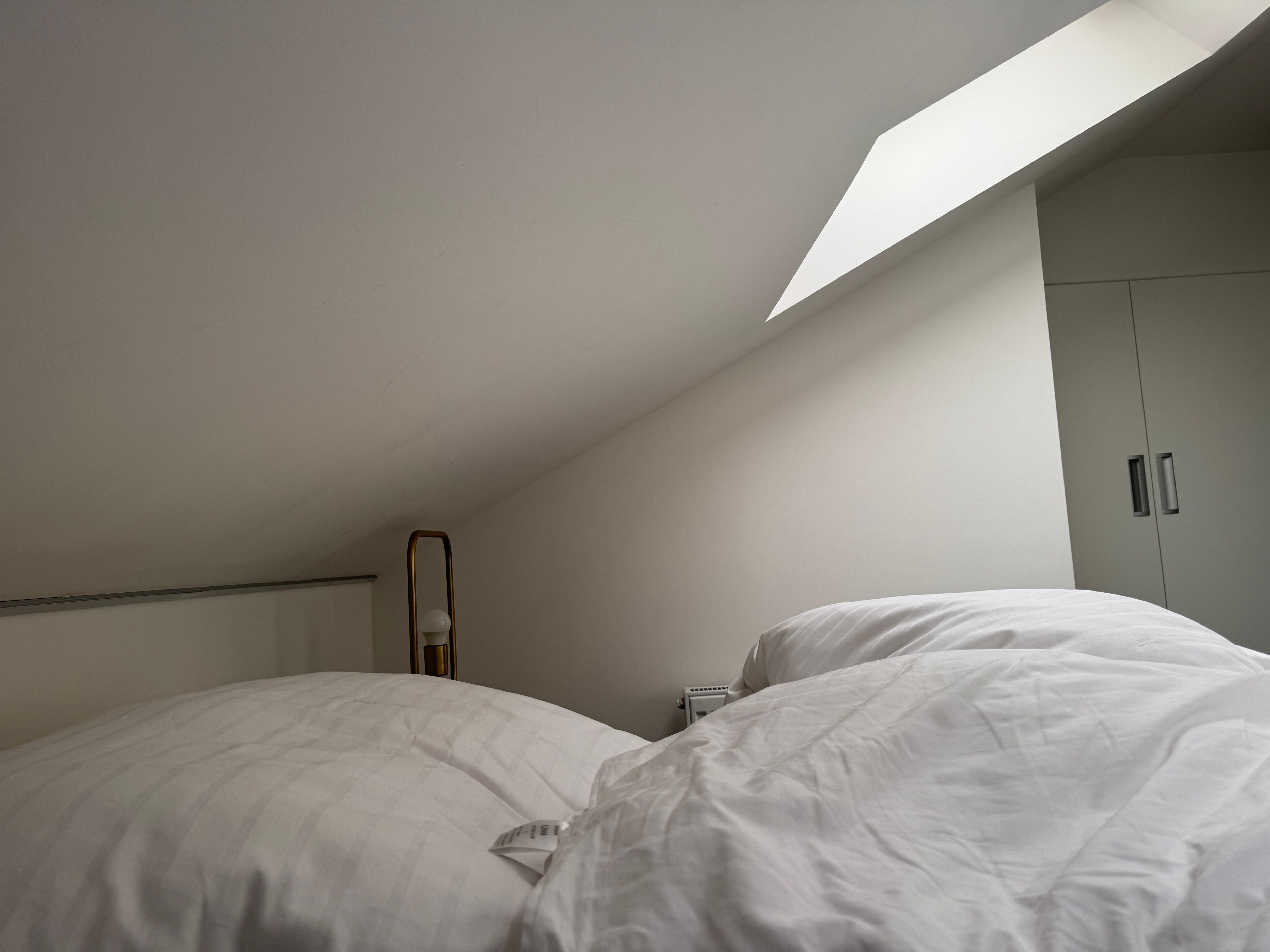 Taken at 5:30am in the upper part of the flat. The blinds are on but clearly useless. Bring a mask and if you are tall, you will spend most of your time bent and stressed to bump your head on the ceiling.