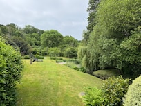 Large lawn with sun loungers, and pond