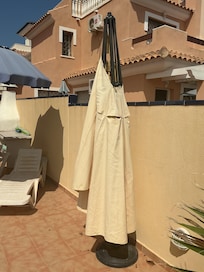 Cream parasol broken and unusable.