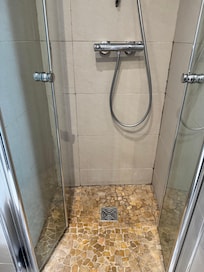 Tiny shower with toilet in front of it