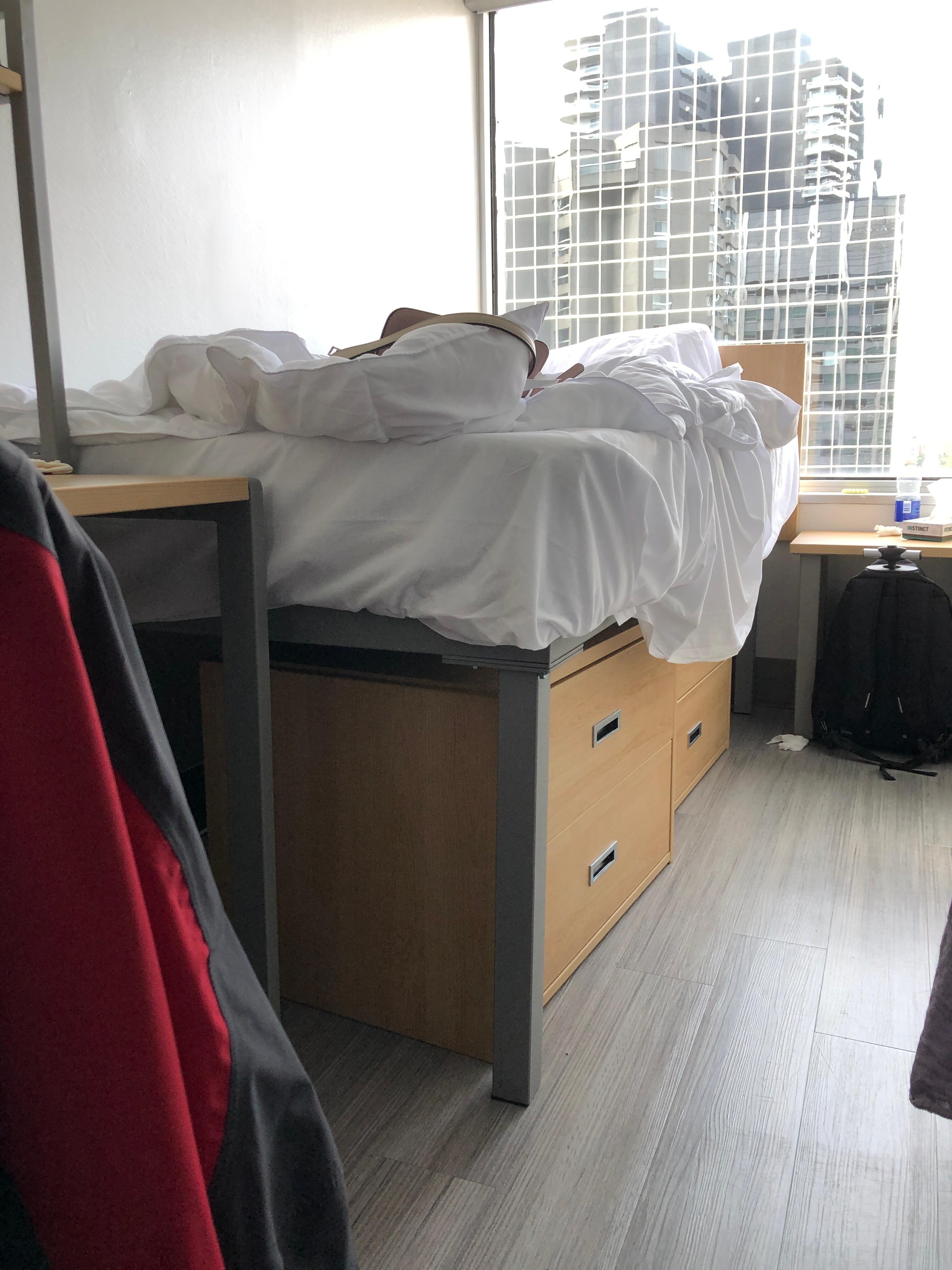 The top of the bed mattress is higher than the top of the desk.
