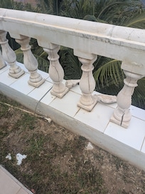 Crumbling pillars surrounding outdoor space. The hot tub in the second pic is broken.