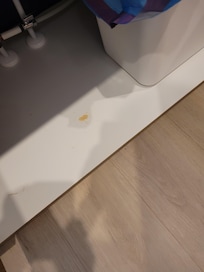 under garbage can in lower cupboard