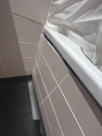 Bathroom panel is poor state after what looks like a repair?