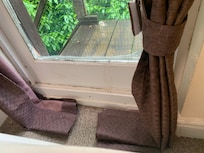 Oversized curtain on the floor - window area not clean