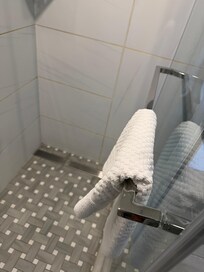 The towel bar in the shower is inside the shower not outside.