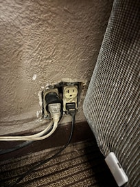 This is a wall plus between the two beds and very close to one of them. I believe this is not only a fire hazard but a codes violation as well.