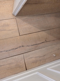 The poorly installed floor boards.