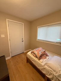 Single bedroom, with hole in blind and outside door.