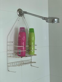 Shampoo and conditioner in a rusted and cracked shower holder. No soap.