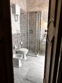 Deluxe room toilet and shower. The door opens to the room (with canopy bed).