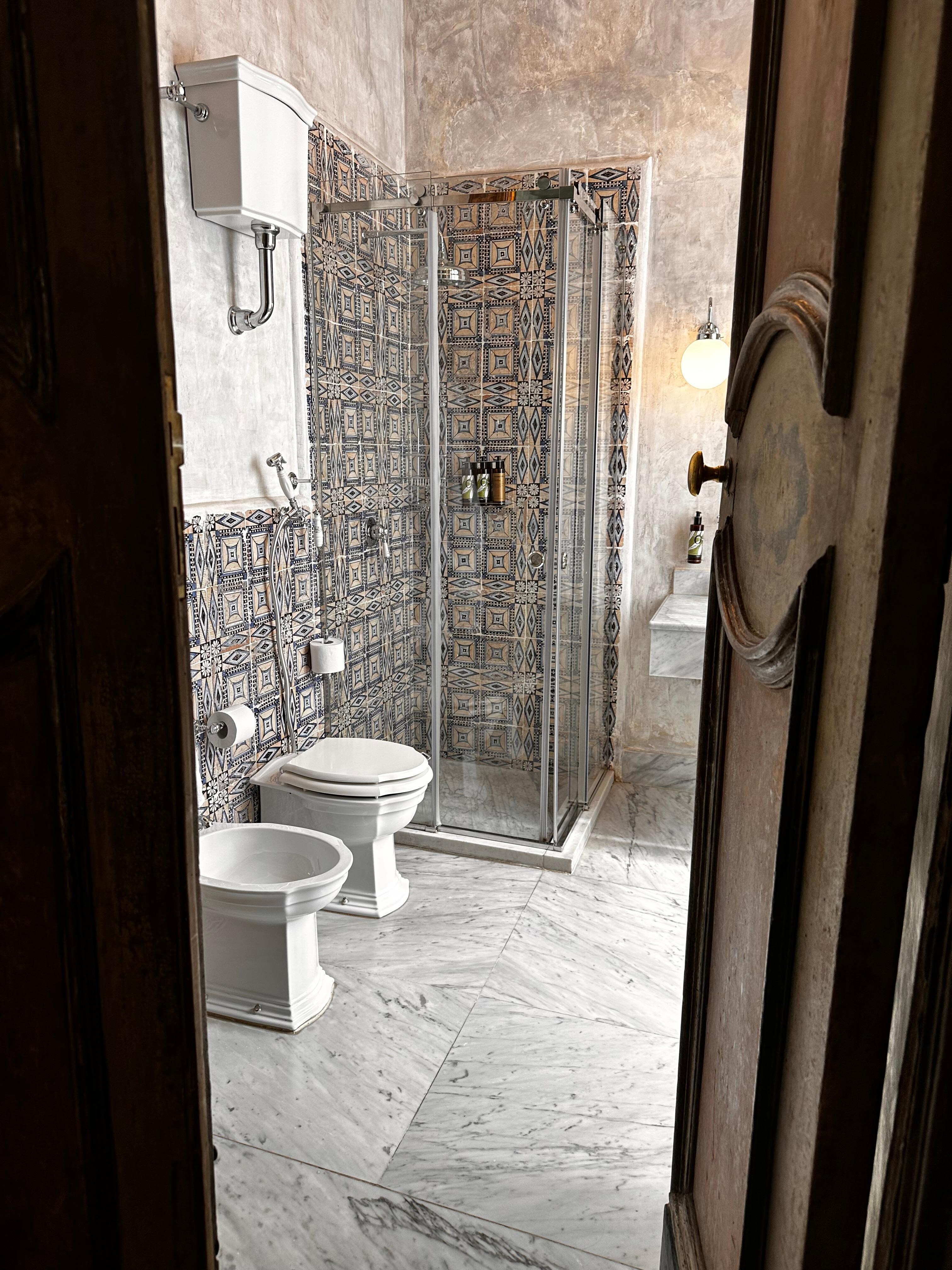 Deluxe room toilet and shower.  The door opens to the room (with canopy bed).
