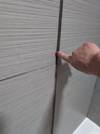 Shower tile with rough edges protruding.