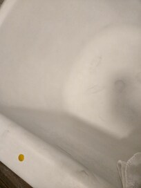 Some random stickers, hair, and unclean looking tub.