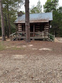 Front of Cabin with a swing. And rocking chairs on front porch