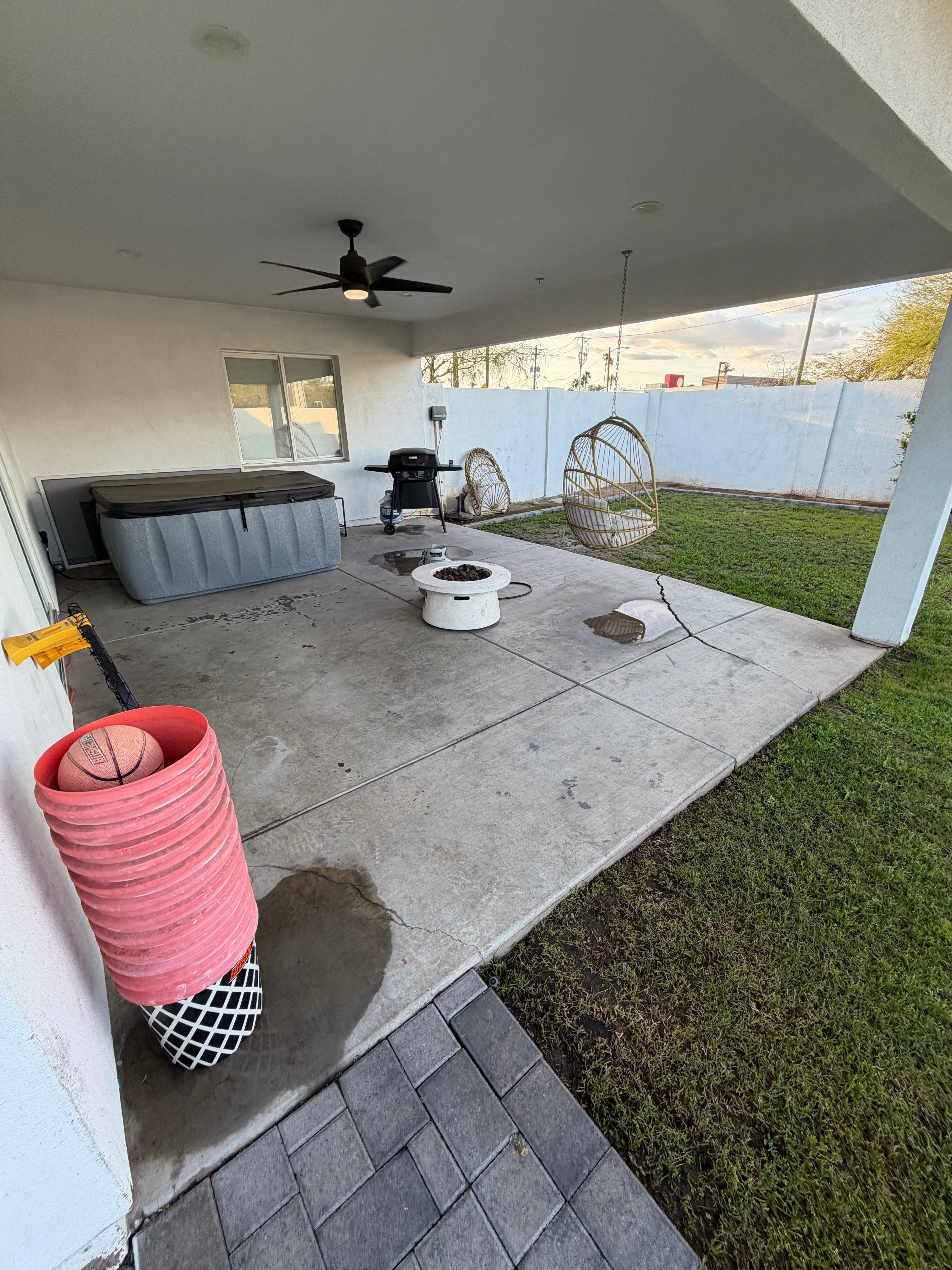 Patio with no furniture. Notice the buckets and deflated balls in the front corner. 