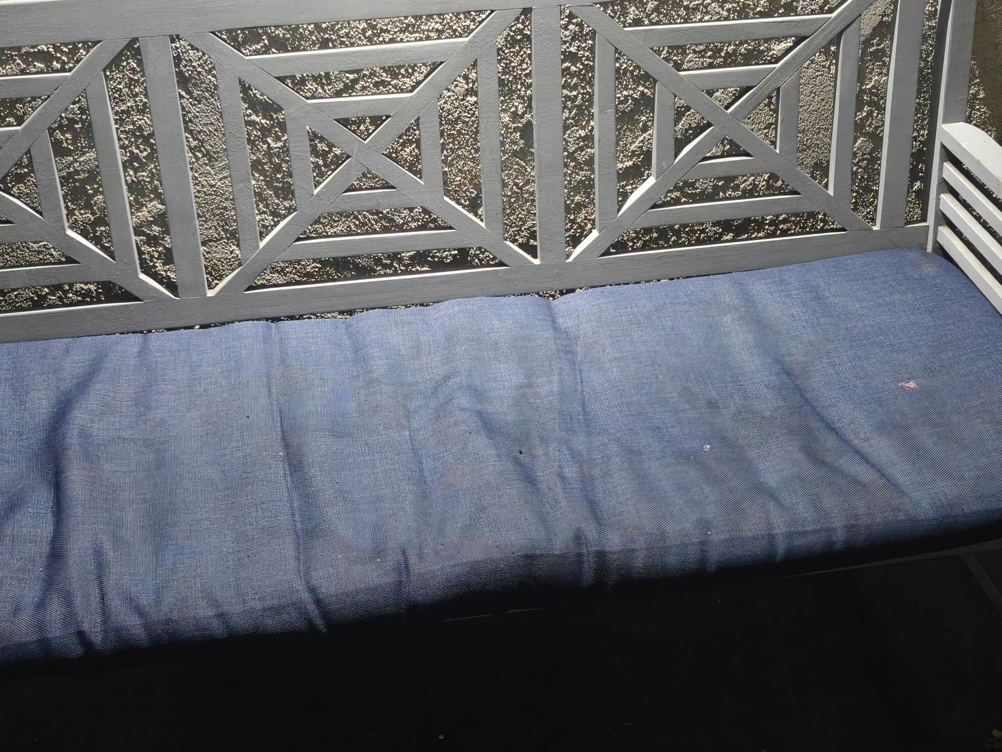 Bench in outdoor hallway appears unclean