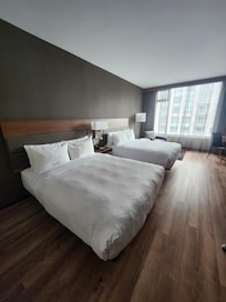 Two queen beds with no carpet on the floor.