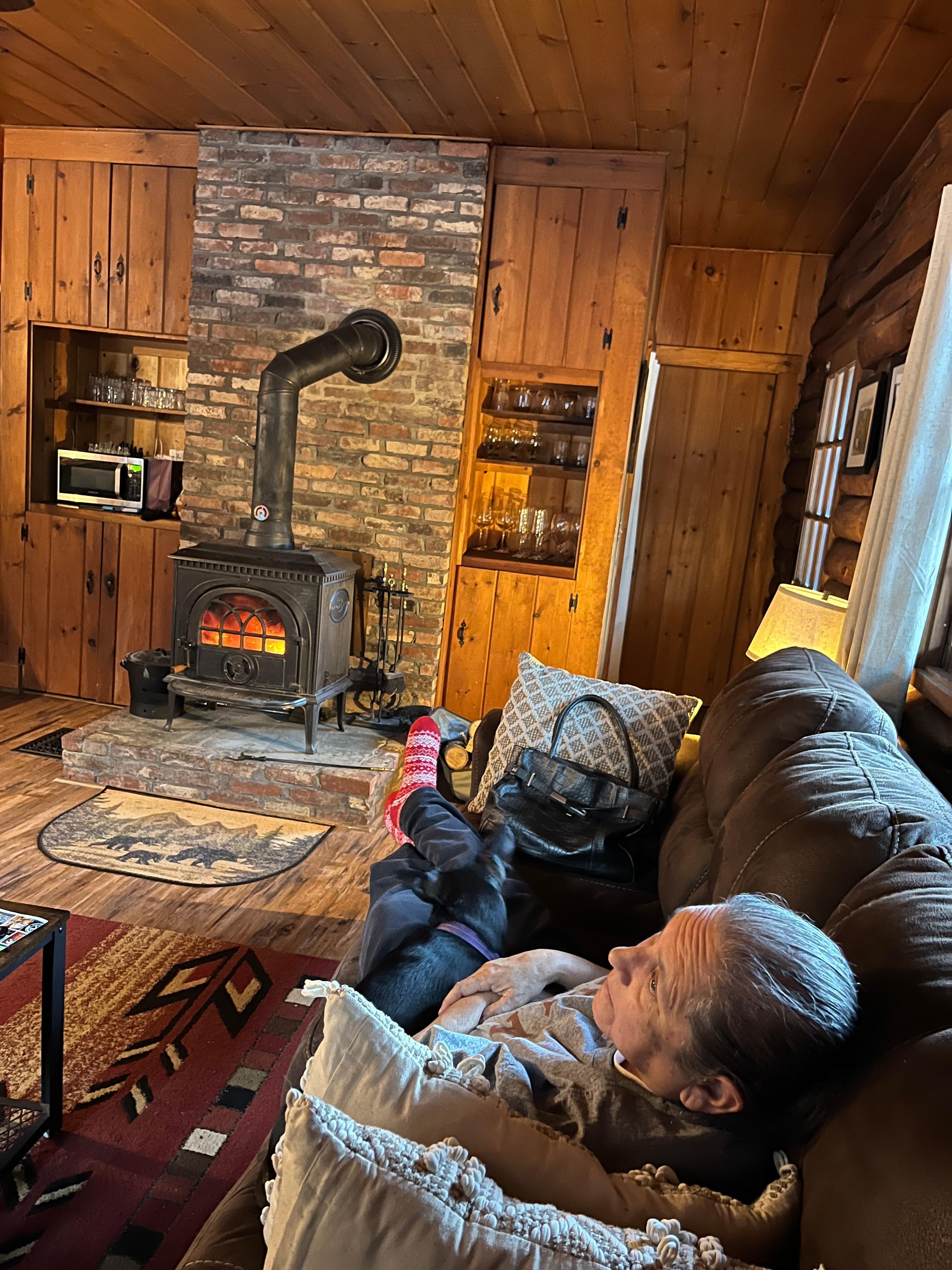 My aunt enjoying the wood-burning stove.