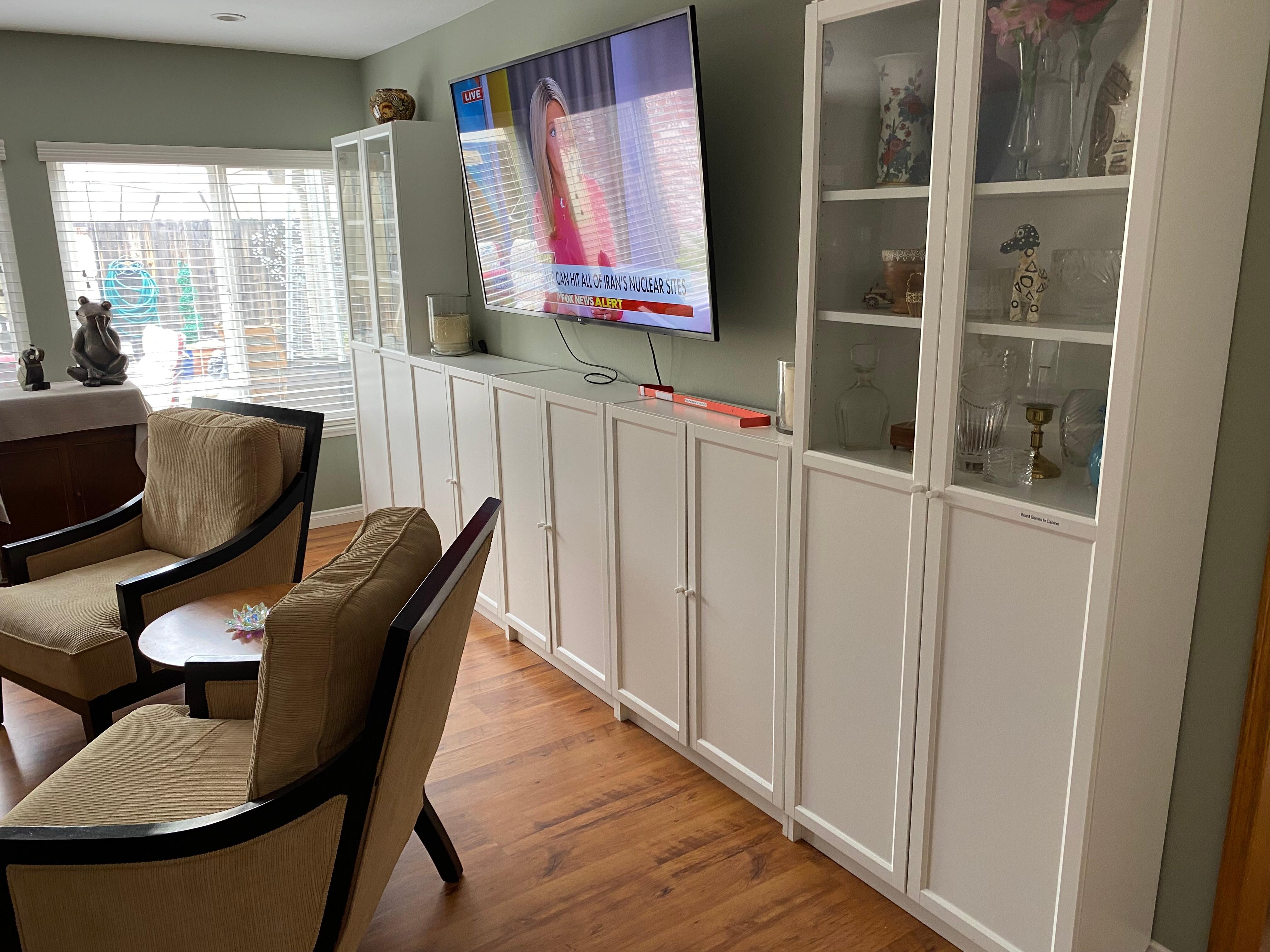 Living room with tv, spacious and comfortable sofas and chairs, and game cabinets. 