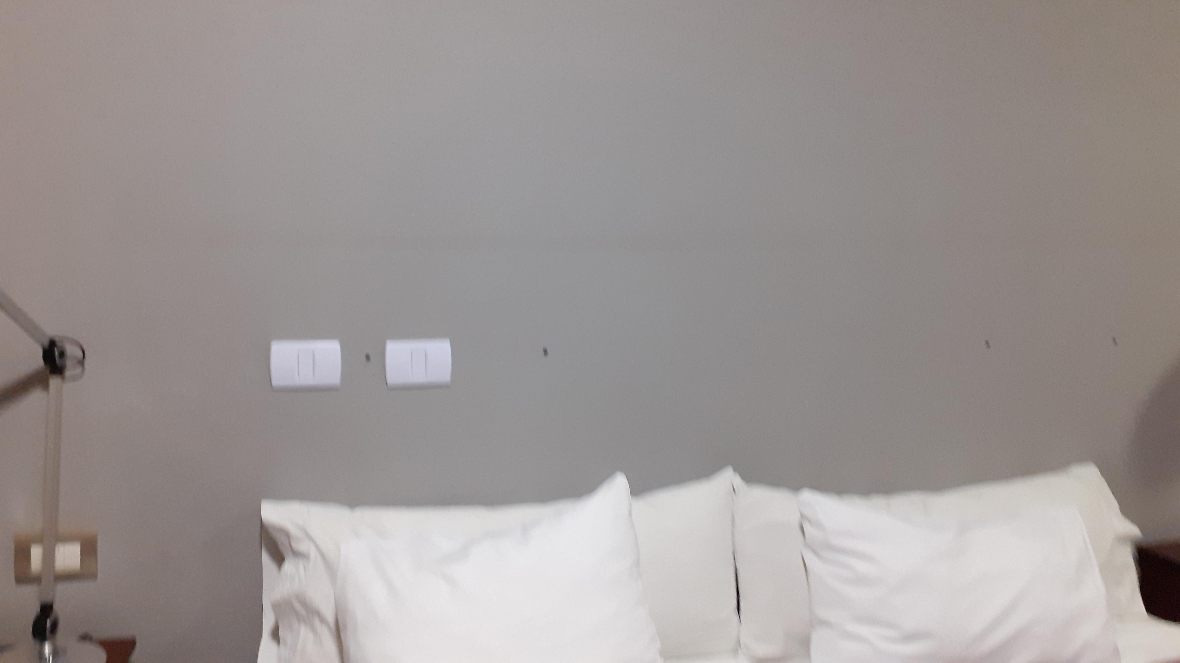 Parede com manchas e buracos de cabeceira retirada